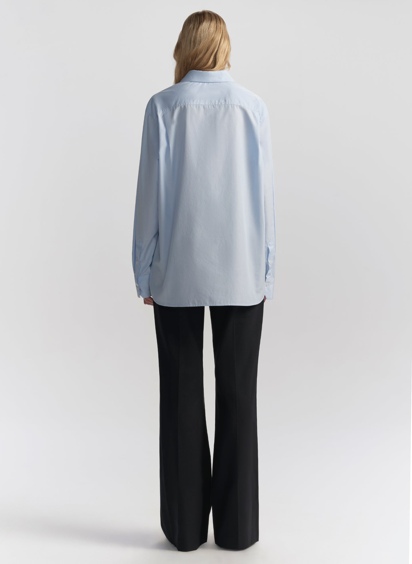 woman wearing light blue shirt and black pants