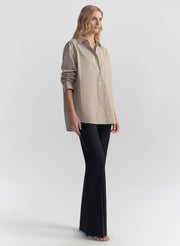 woman wearing brown striped shirt and black pants