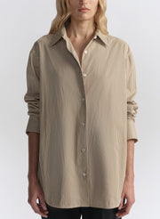 woman wearing brown striped shirt and black pants