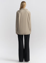 woman wearing brown striped shirt and black pants