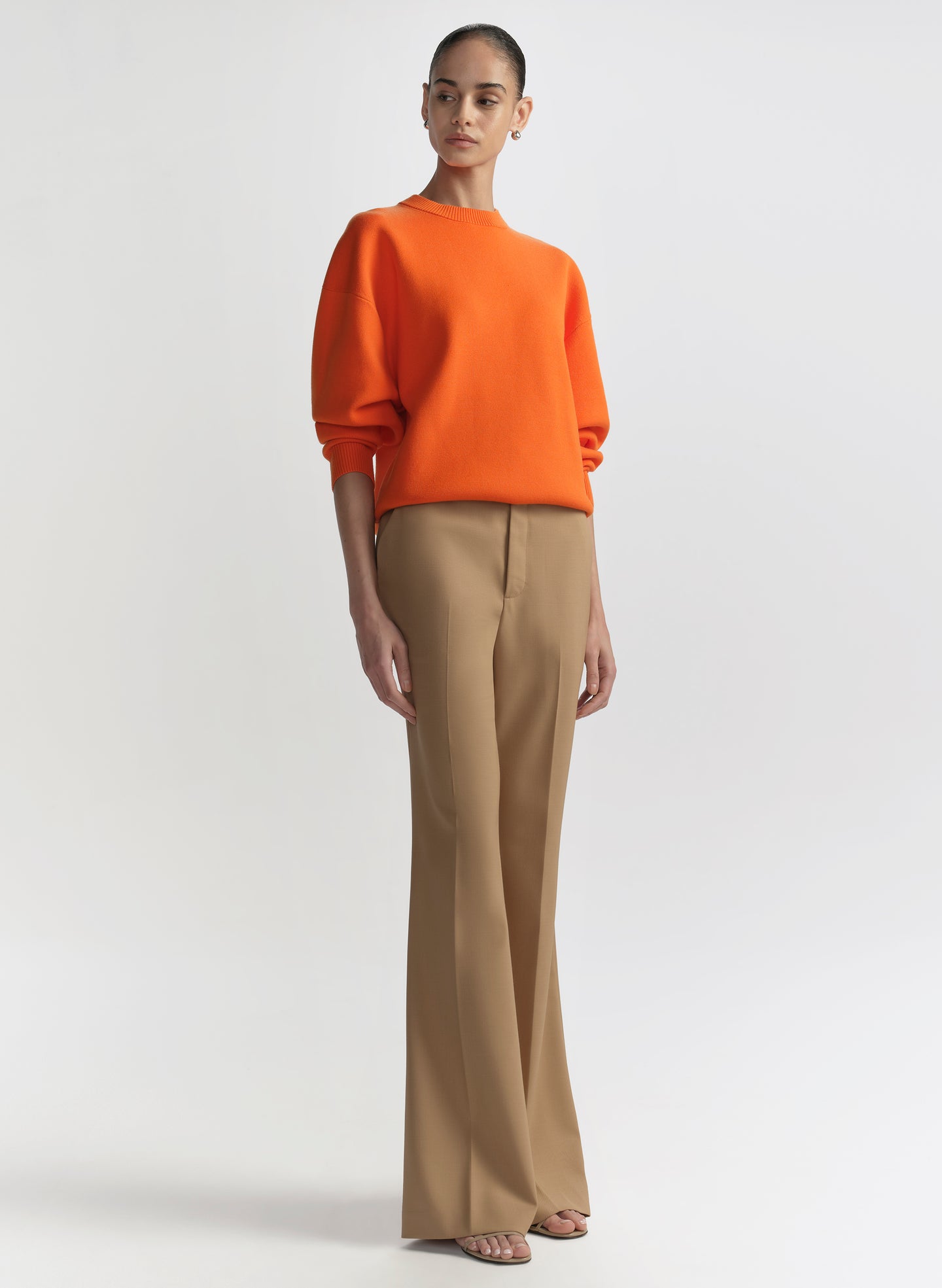 woman wearing orange sweater and tan pants