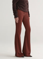 woman wearing a brown off-shoulder top and maroon pants on a white background