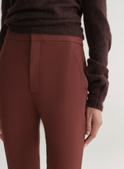 woman wearing a brown off-shoulder top and maroon pants on a white background