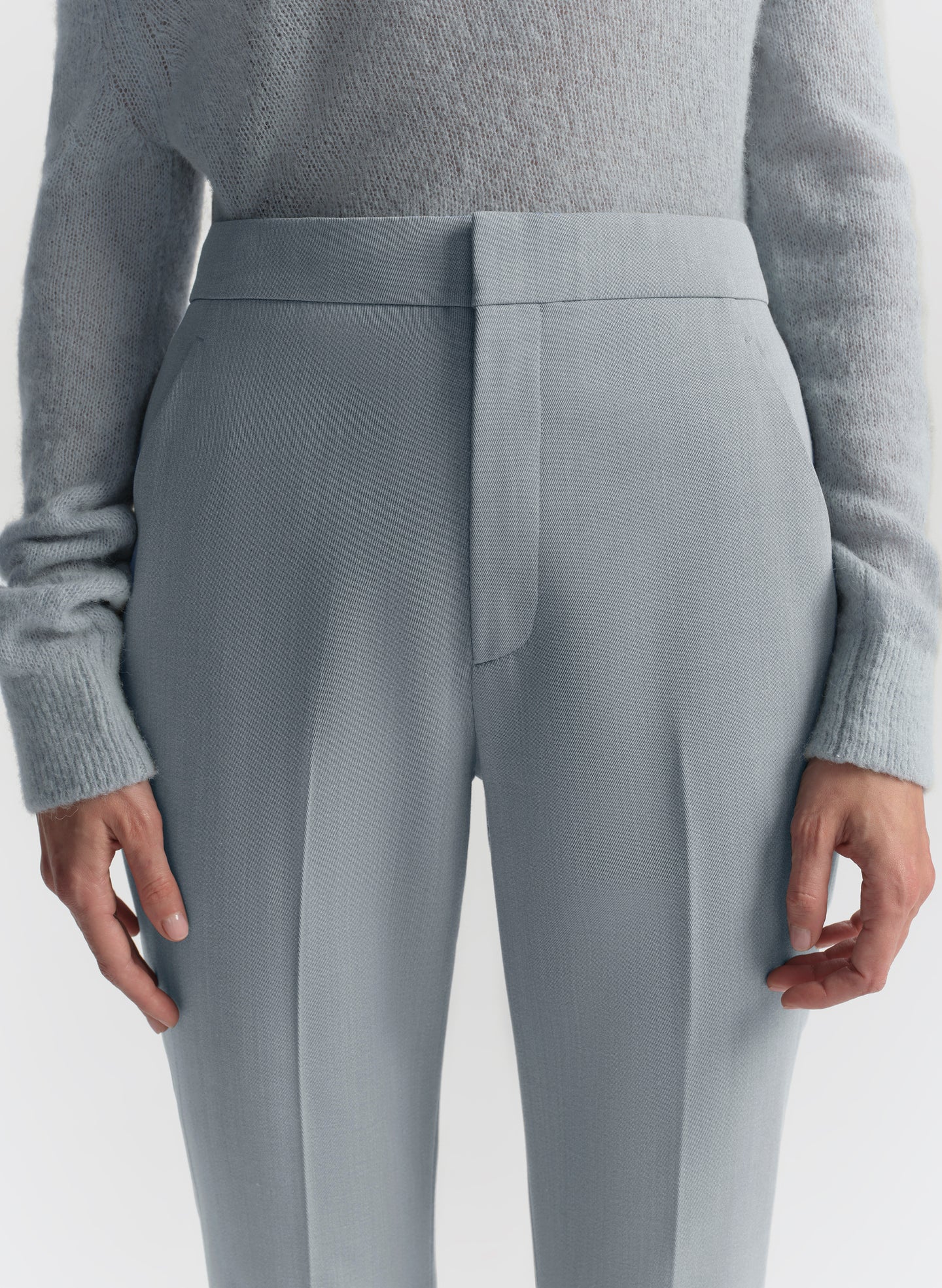 Gray pants worn with a gray sweater on a white background