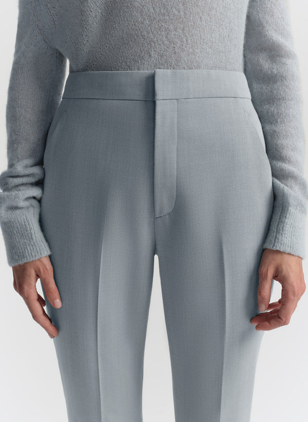 Gray pants worn with a gray sweater on a white background