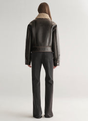 woman wearing brown jacket and black jeans