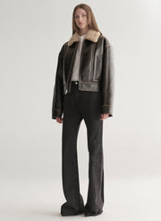 woman wearing brown jacket and black jeans