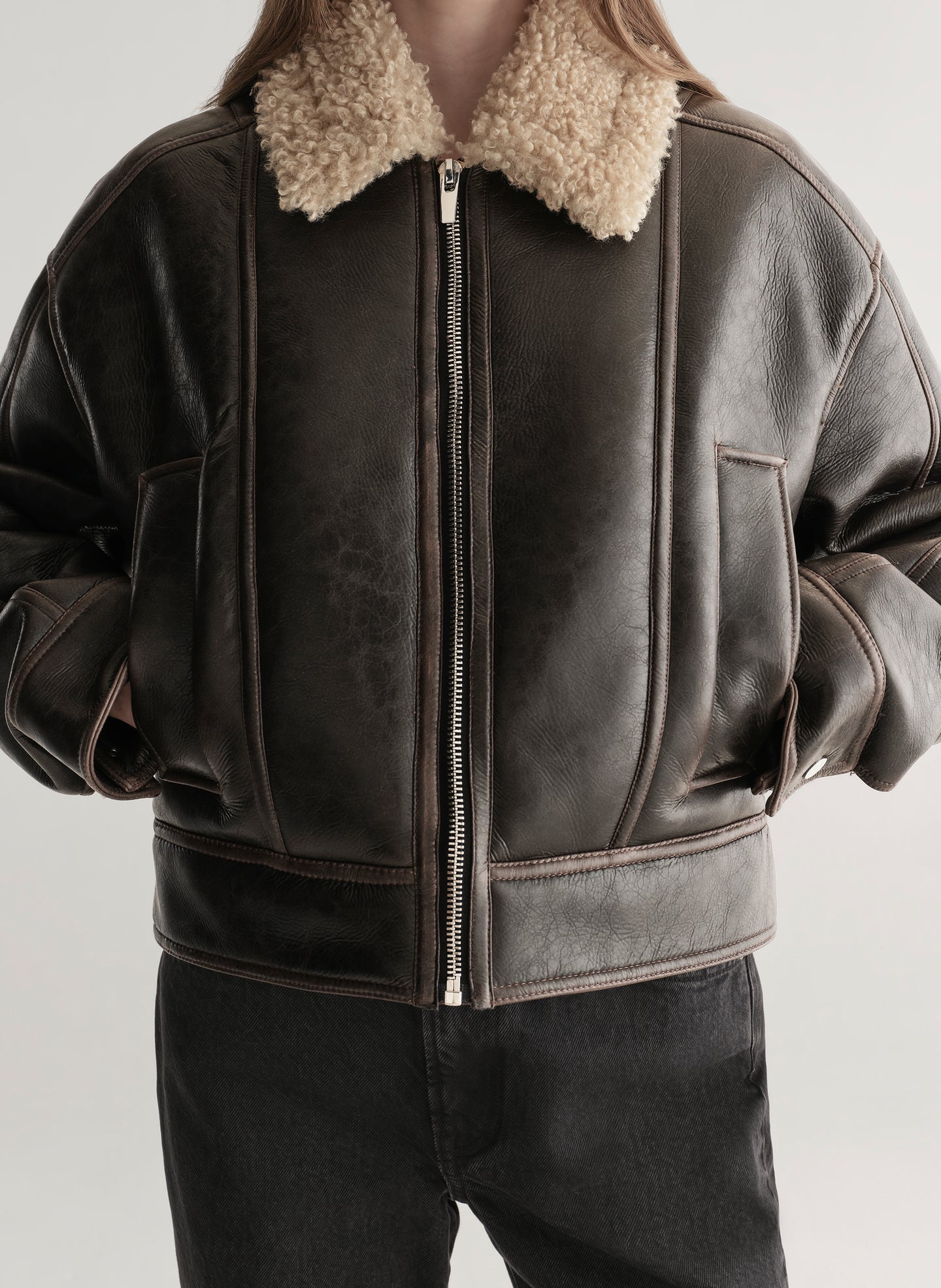 woman wearing brown jacket and black jeans