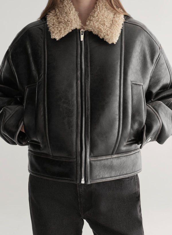 woman wearing faux leather and shearling jacket