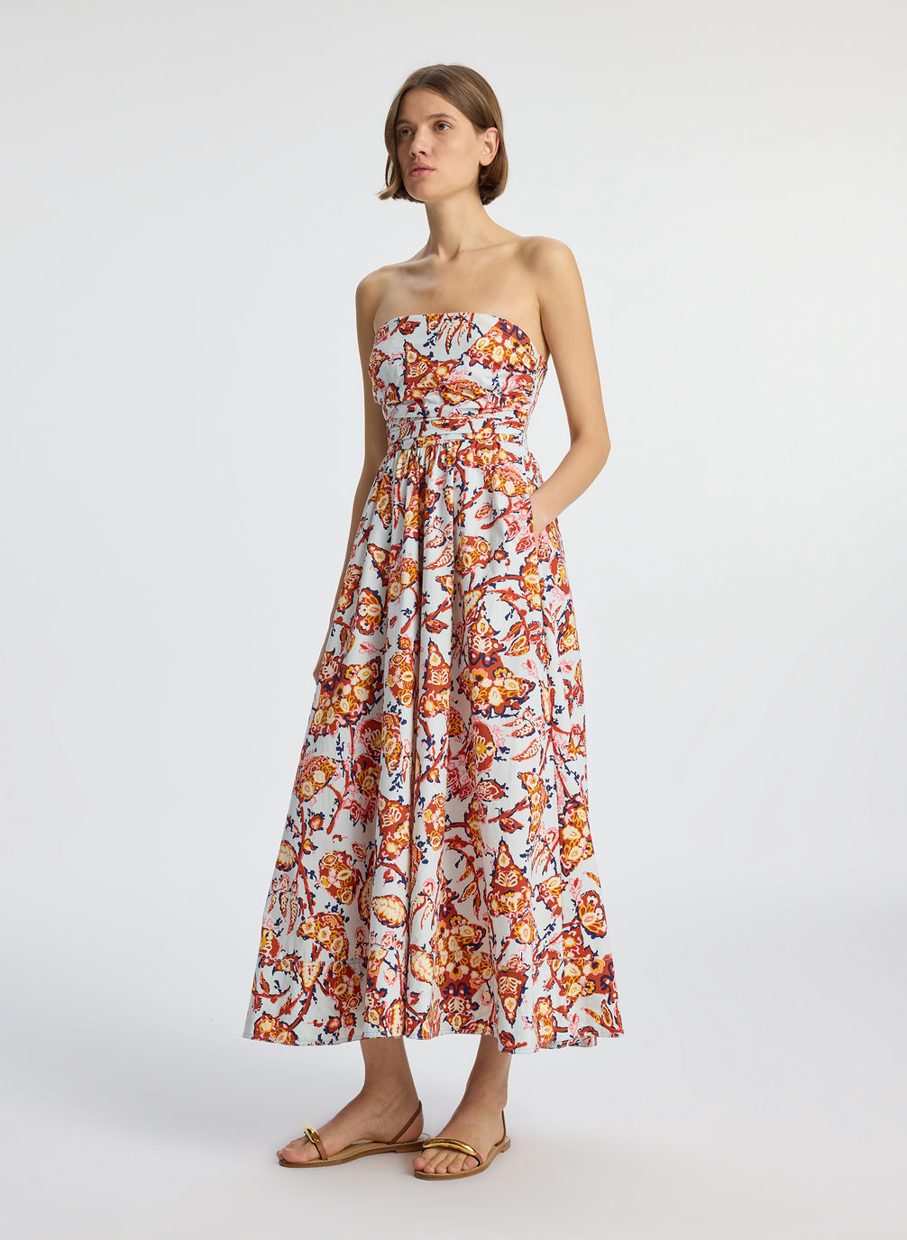side view of woman wearing multicolor printed strapless midi dress