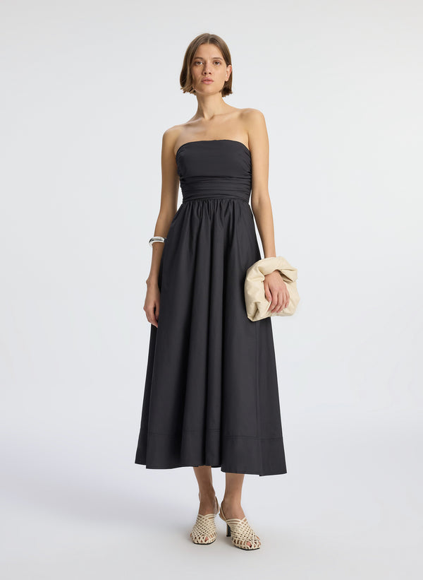 front view of woman wearing black strapless midi dress