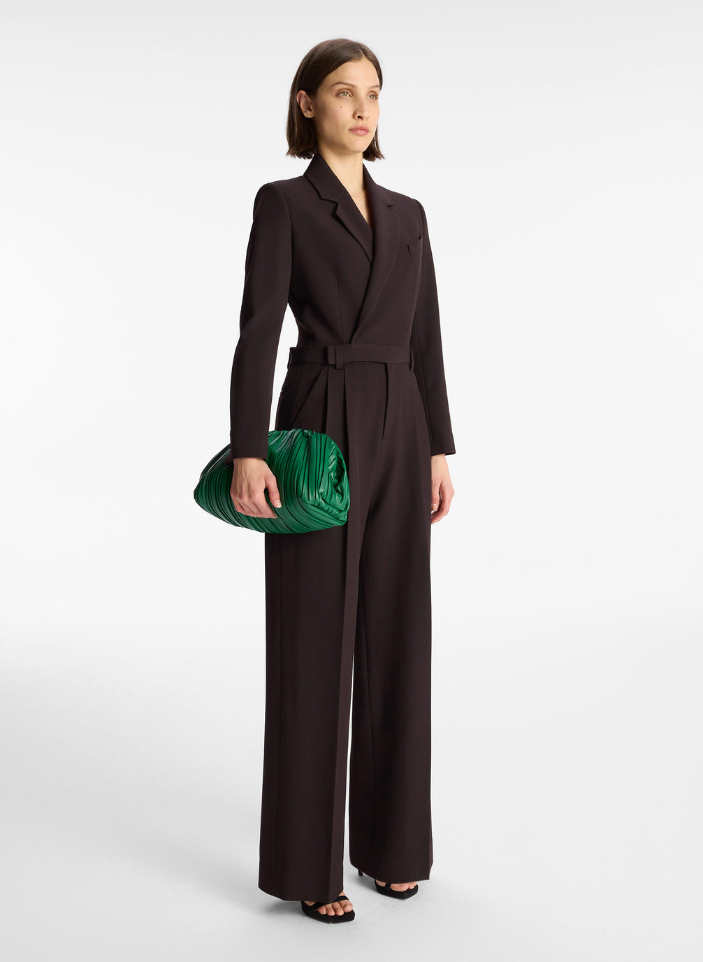 side view of woman wearing black long sleeve jumpsuit with back cutout