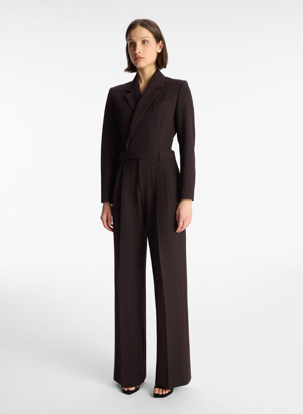 side view of woman wearing black long sleeve jumpsuit with back cutout