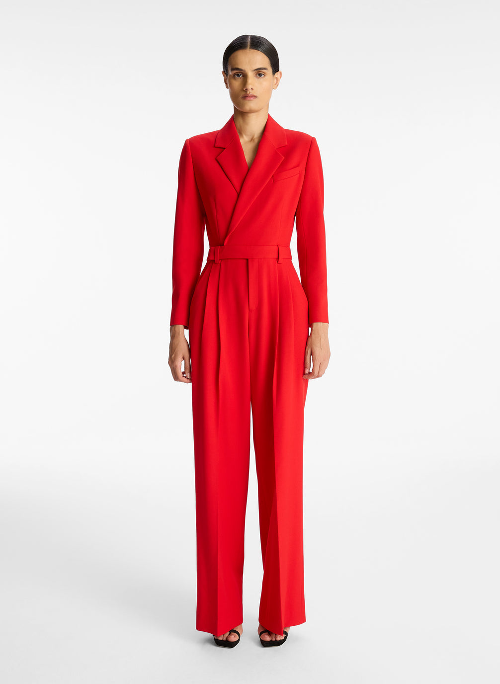 front view of woman wearing red long sleeve jumpsuit with back cutout