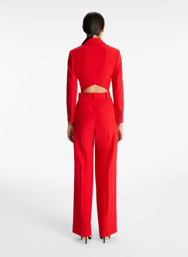 back view of woman wearing red long sleeve jumpsuit with back cutout