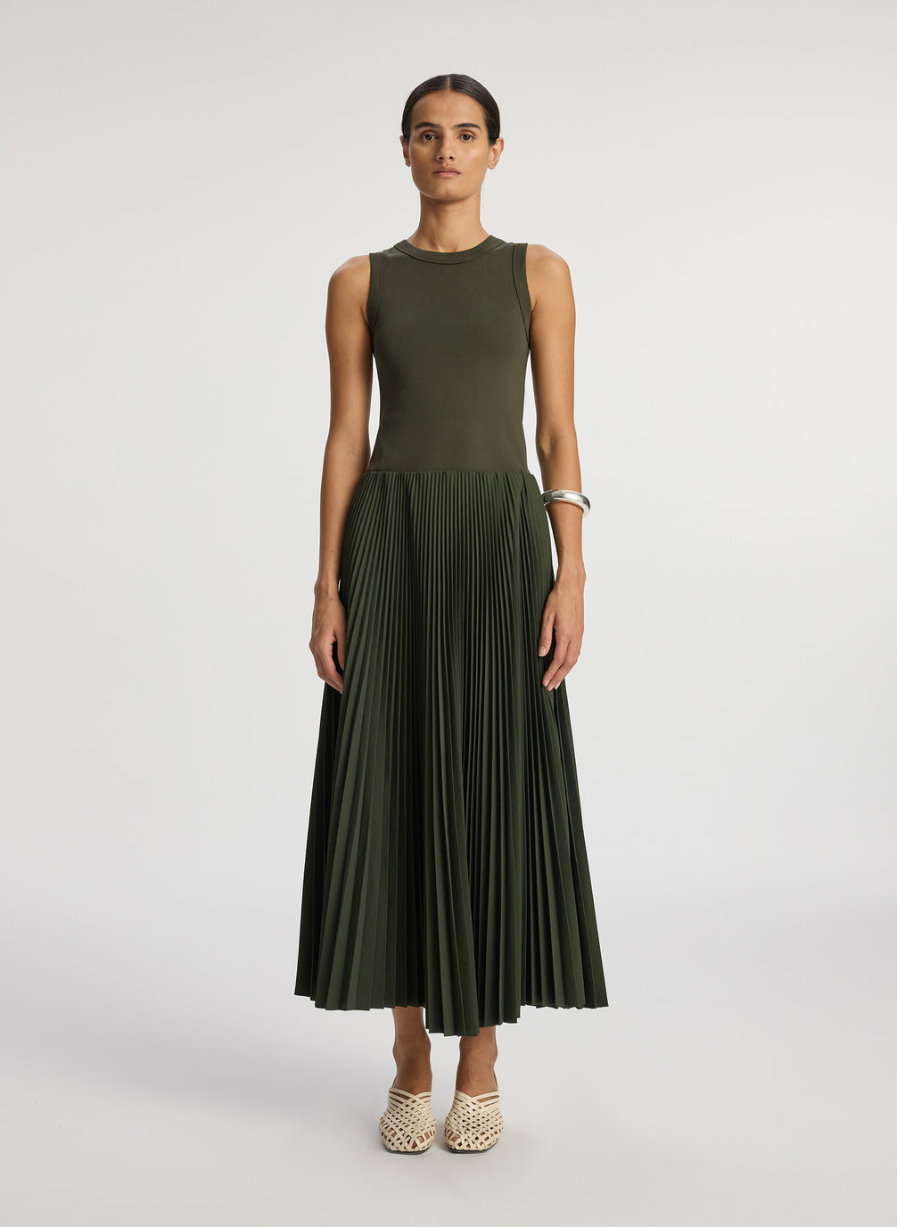 front  view of woman wearing olive green tank with olive green pleated midi skirt