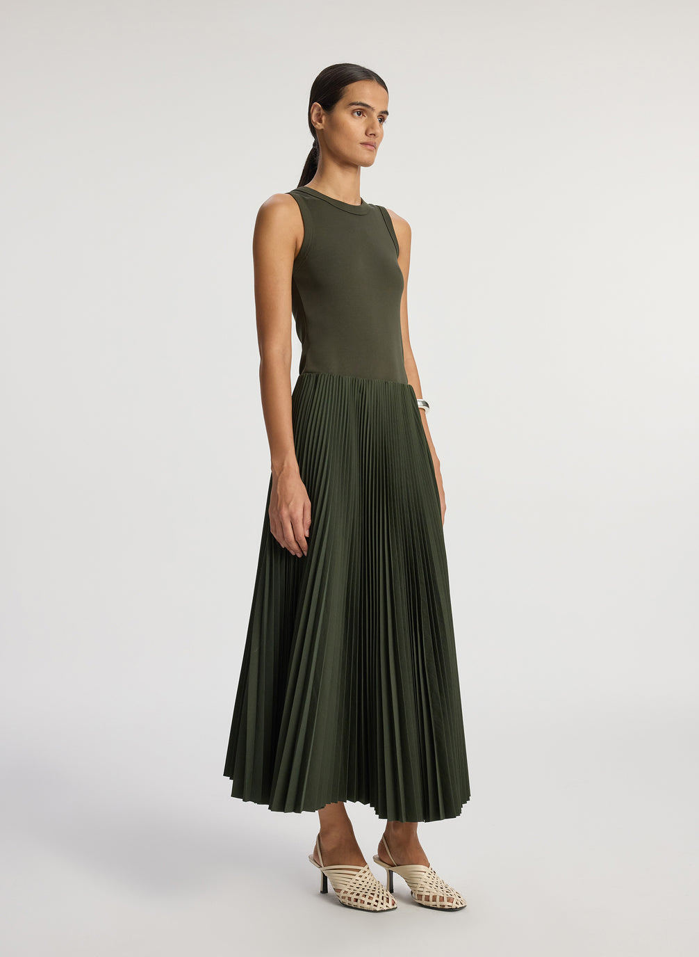 front view of woman wearing olive green tank with olive green pleated midi skirt