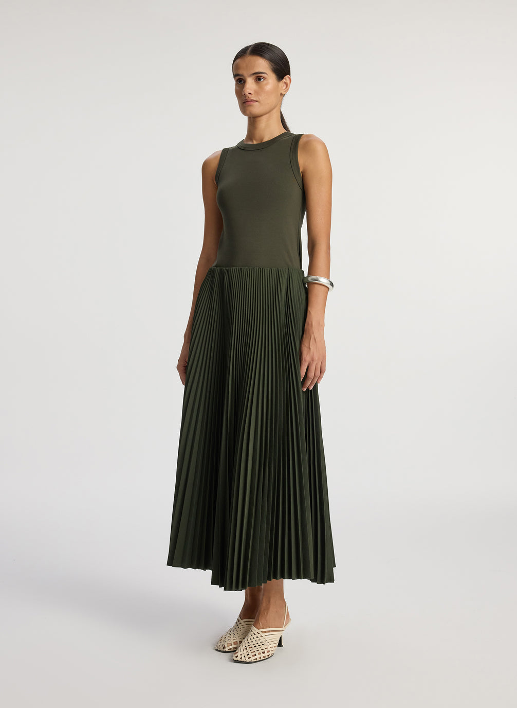 side  view of woman wearing olive green tank with olive green pleated midi skirt