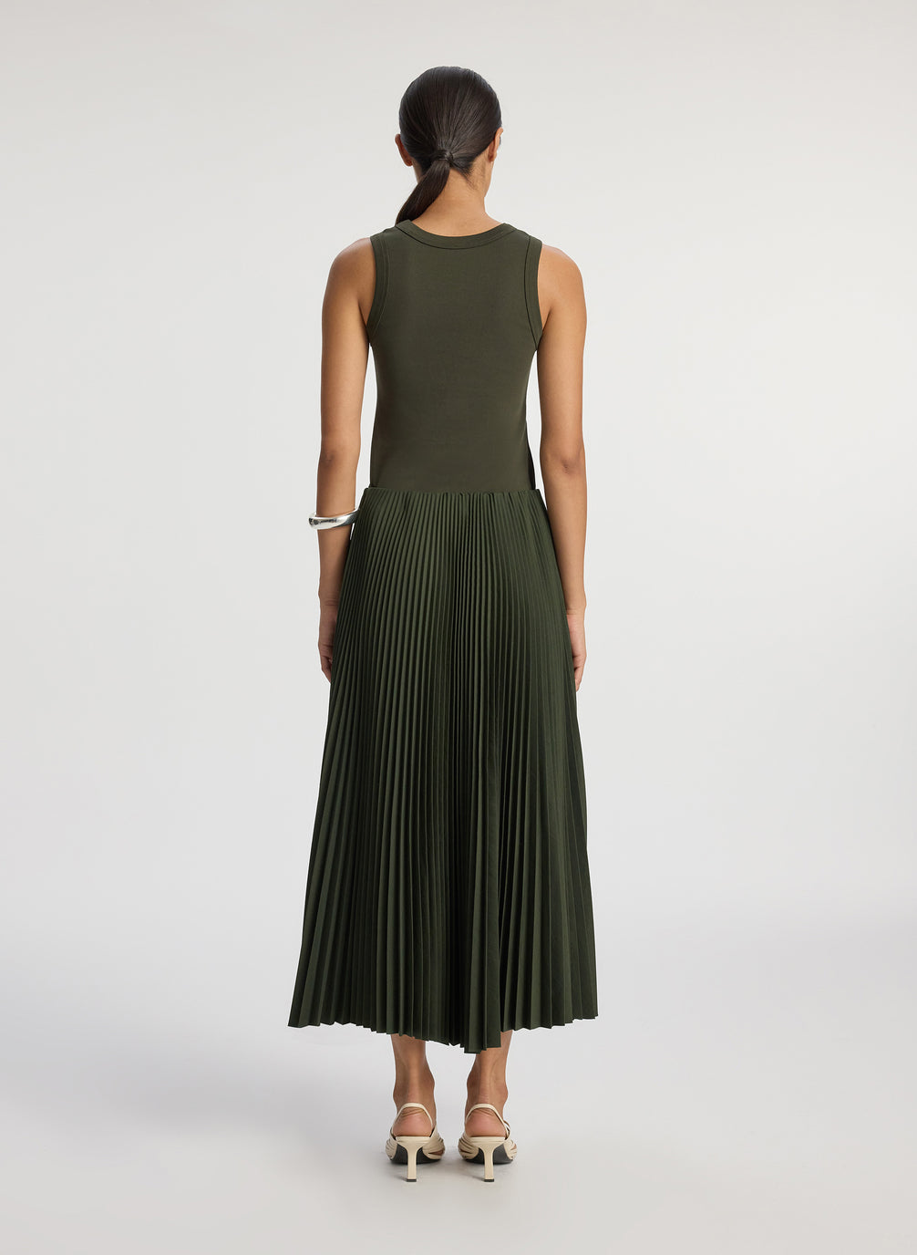 back  view of woman wearing olive green tank with olive green pleated midi skirt