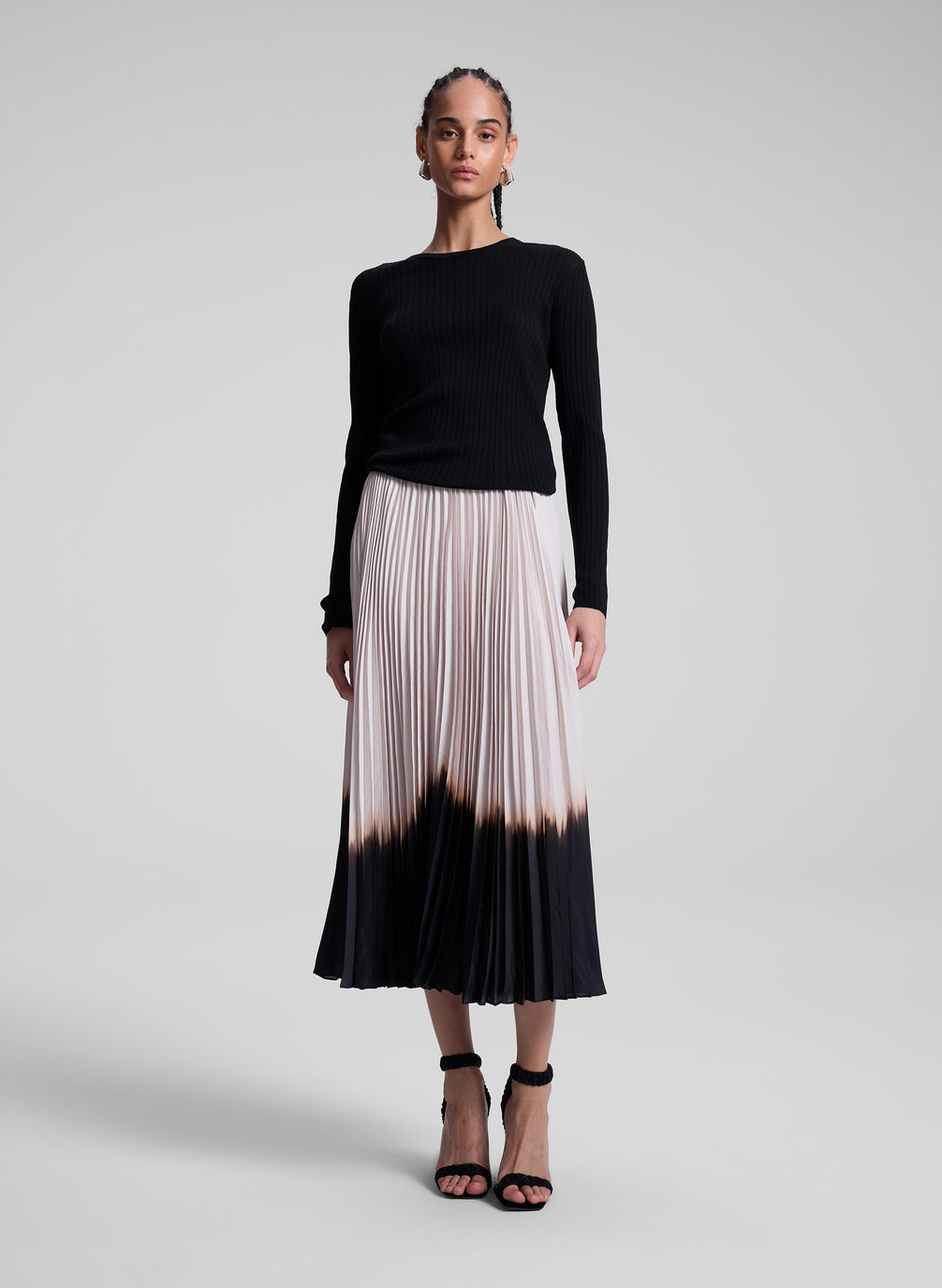 woman wearing black top and dip dye pleated skirt