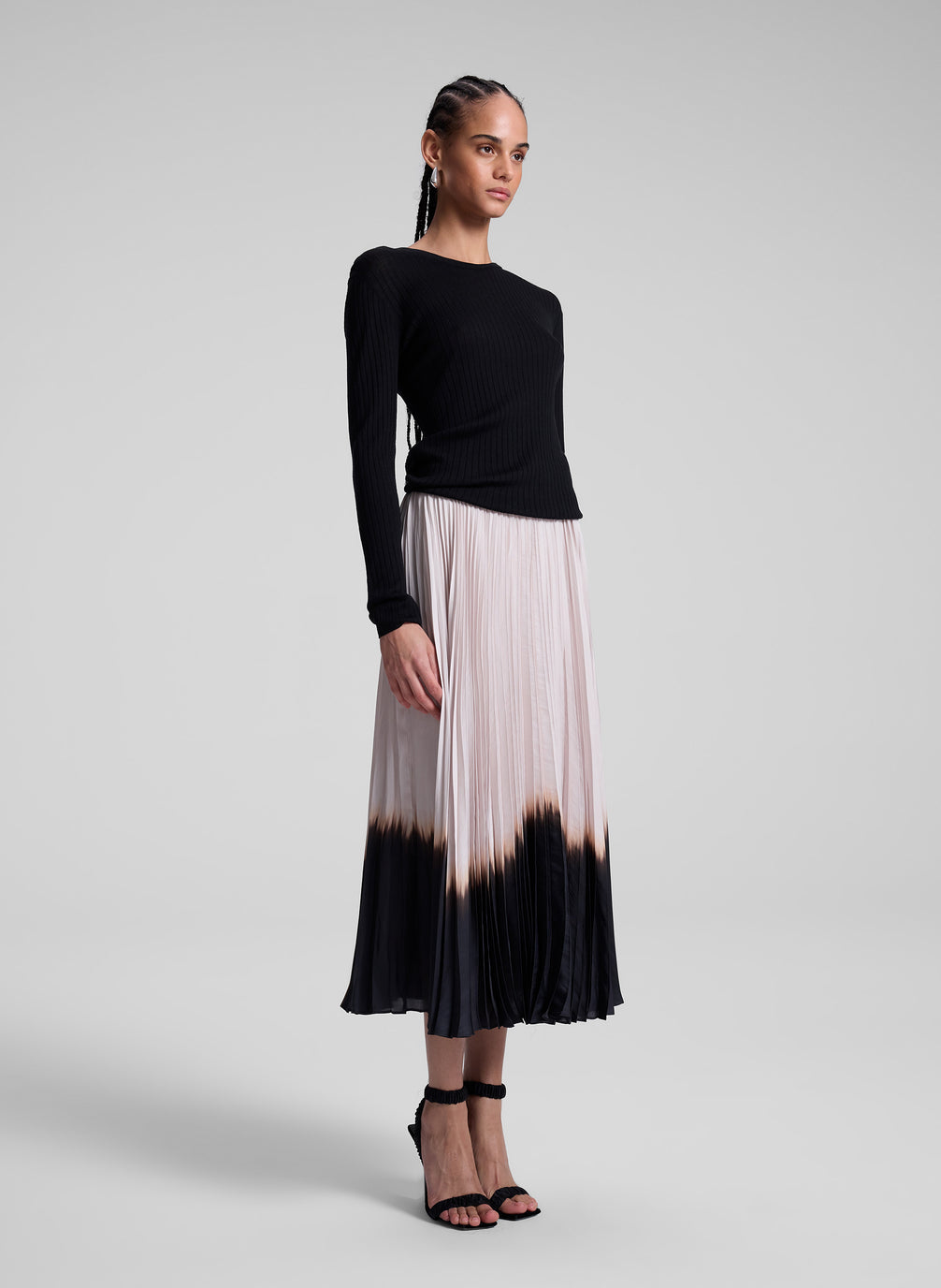 woman wearing black top and dip dye pleated skirt