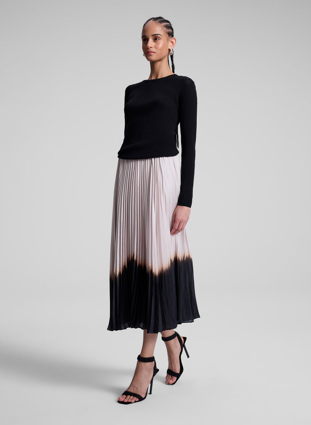 woman wearing black top and dip dye pleated skirt