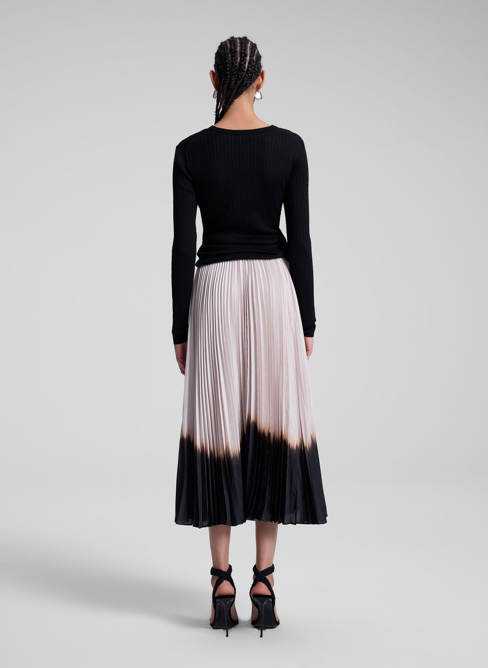 woman wearing black top and dip dye pleated skirt