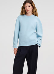 woman wearing light blue sweater with navy wide leg pants