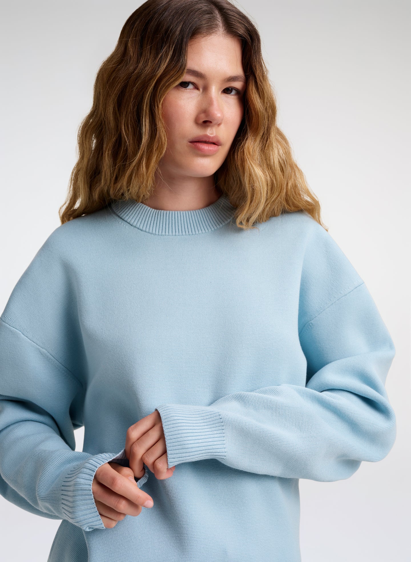 woman wearing light blue crewneck sweater