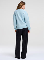 woman wearing light blue crewneck sweater and blue pants