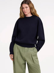woman in navy blue sweater and green pants
