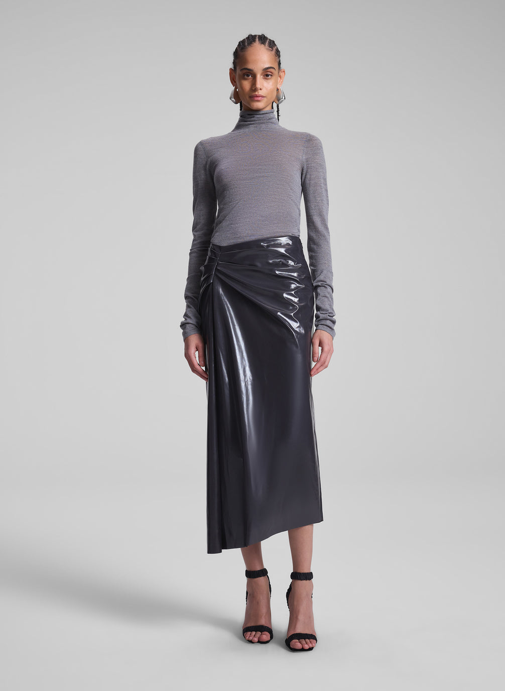 woman wearing grey turtleneck and vegan patent leather skirt