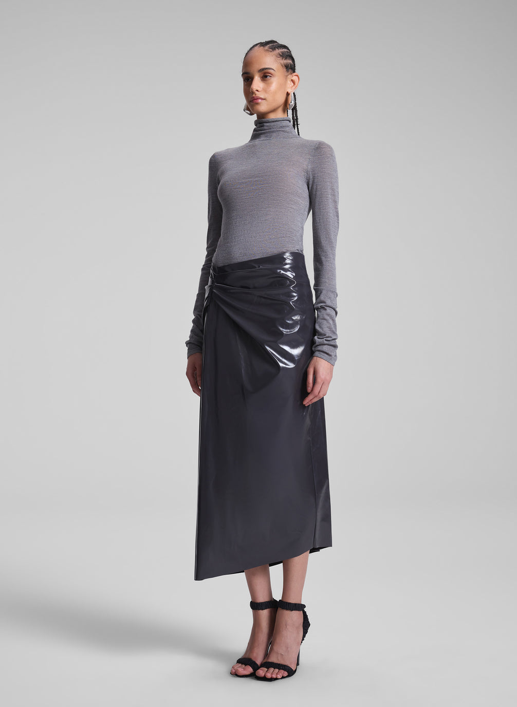 woman wearing grey turtleneck and vegan patent leather skirt