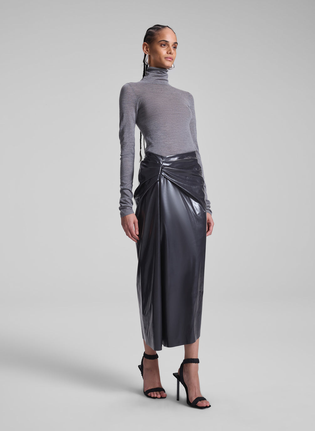 woman wearing grey turtleneck and vegan patent leather skirt