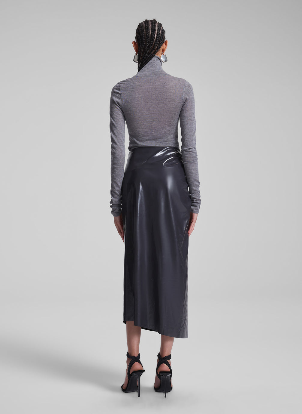 woman wearing grey turtleneck and vegan patent leather skirt