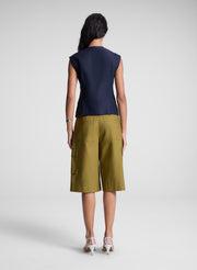 woman wearing blue vest and brown shorts