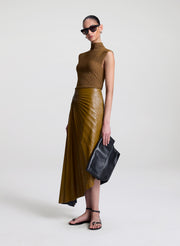 woman wearing brown top and brown pleated vegan leather skirt