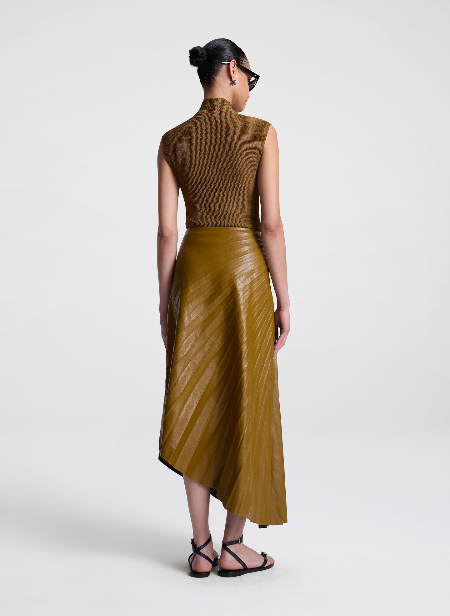 woman wearing brown top and brown pleated vegan leather skirt