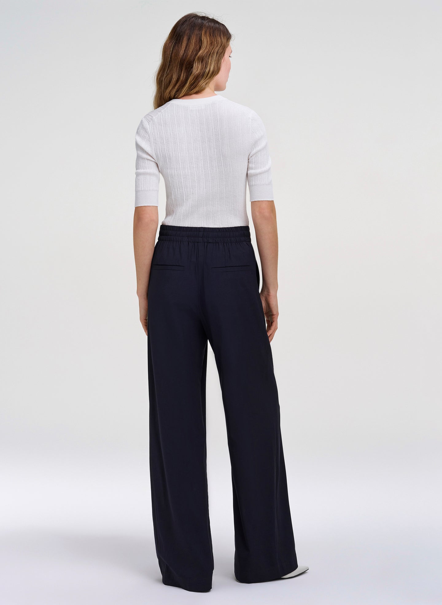 woman wearing white top and navy blue pants