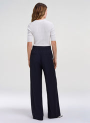 woman wearing white top and navy blue pants