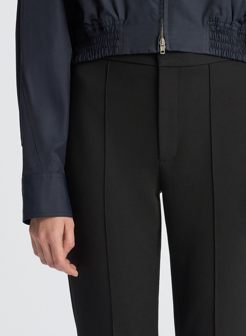 detail  view of woman in navy blue jacket and black ankle pants