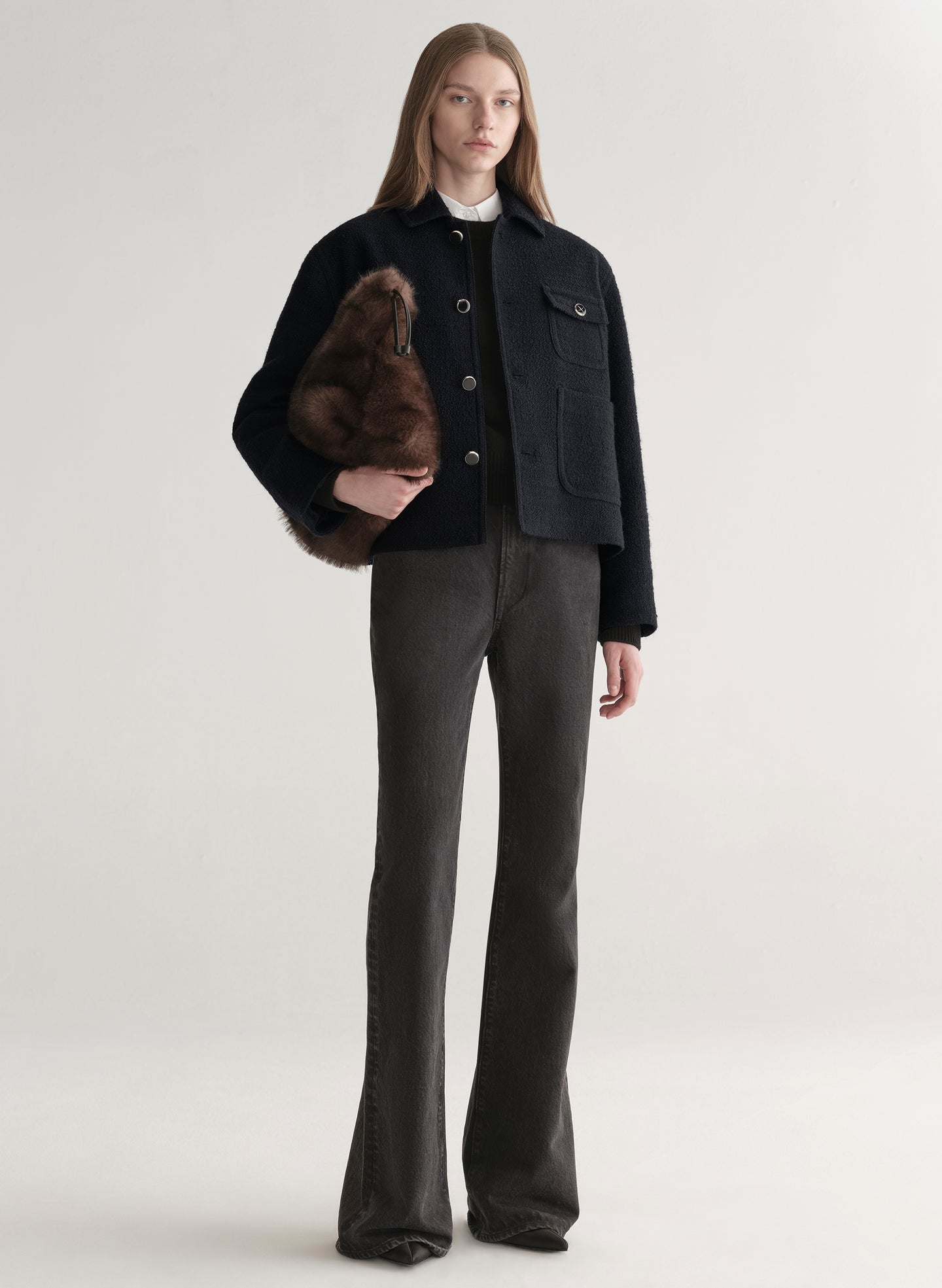 woman wearing deep navy blue jacket with white shirt and black denim jeans