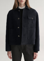 woman wearing deep navy blue jacket with white shirt and black denim jeans