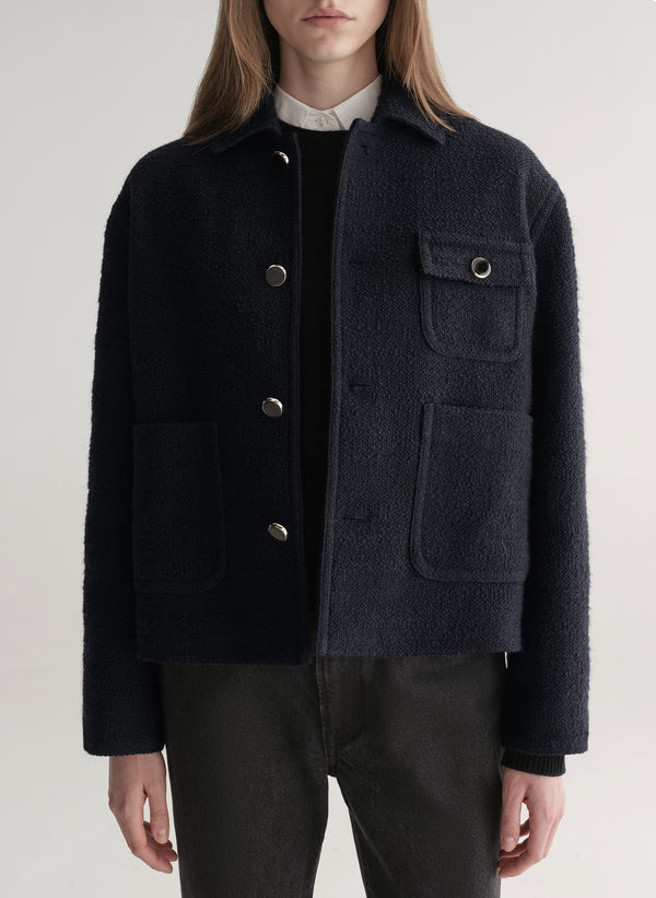 woman wearing deep navy blue jacket with white shirt and black denim jeans