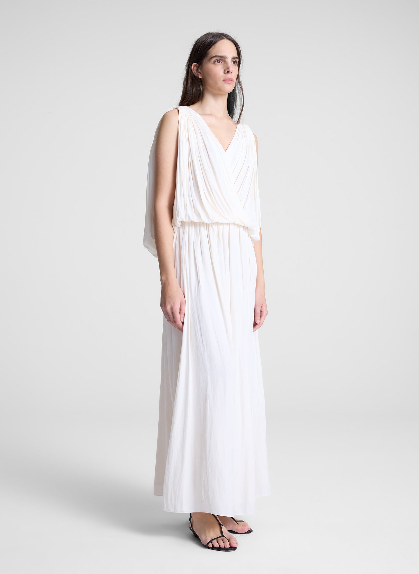 woman wearing white draped top and matching maxi skirt