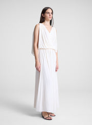 woman wearing white draped top and matching maxi skirt
