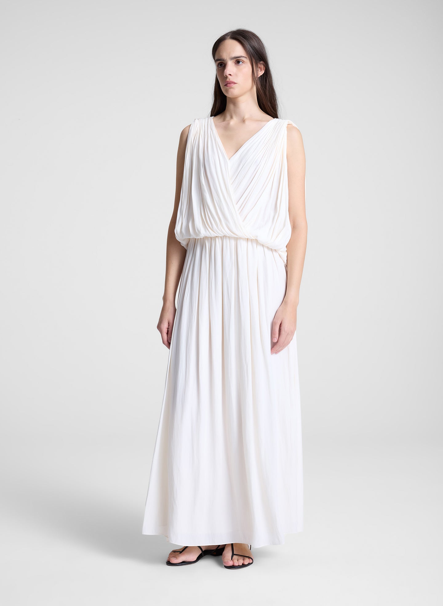 woman wearing white draped top and matching maxi skirt