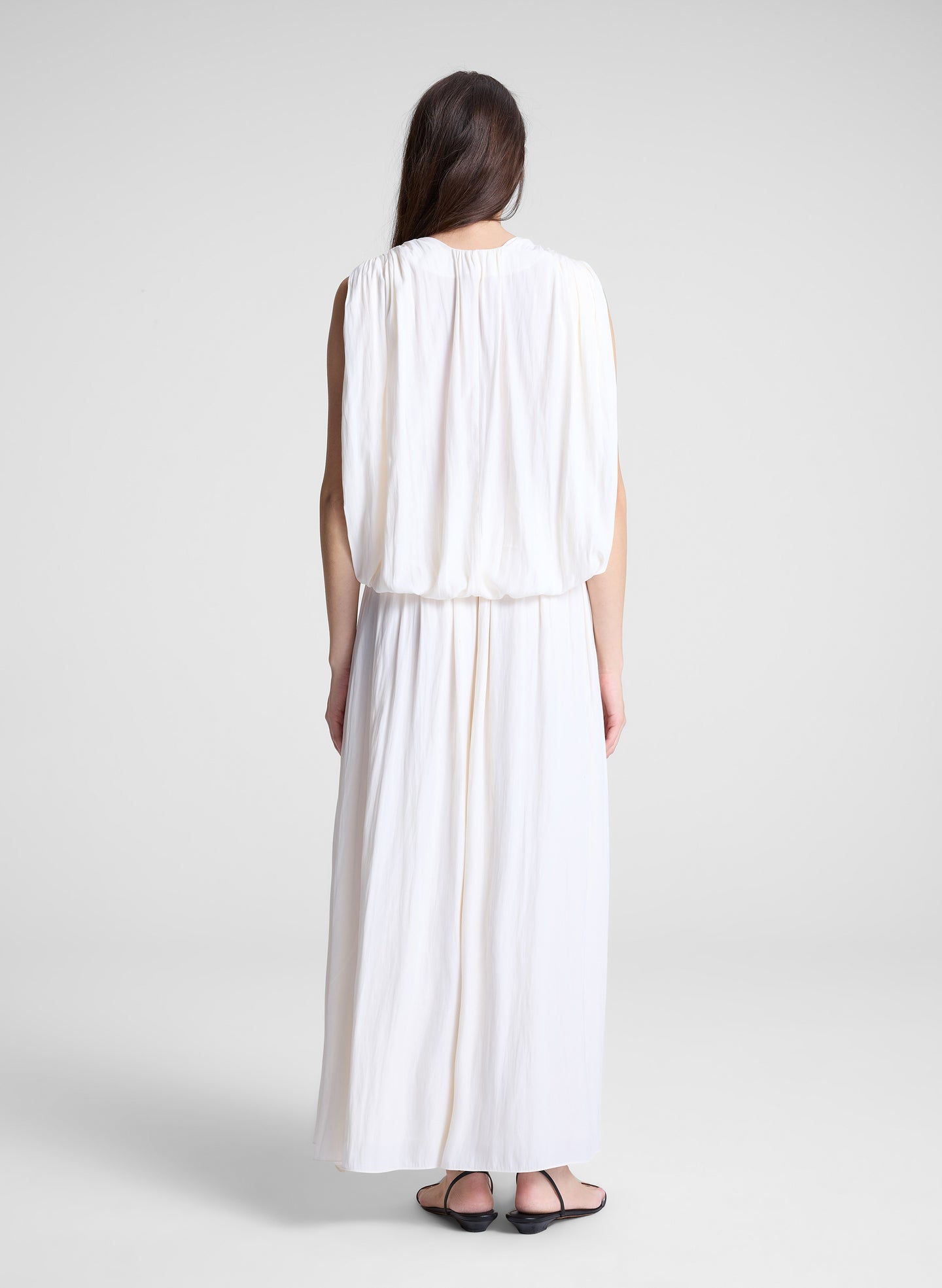 woman wearing white draped top and matching maxi skirt