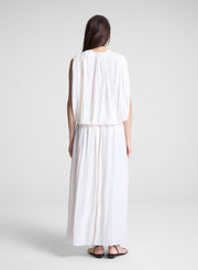 woman wearing white draped top and matching maxi skirt