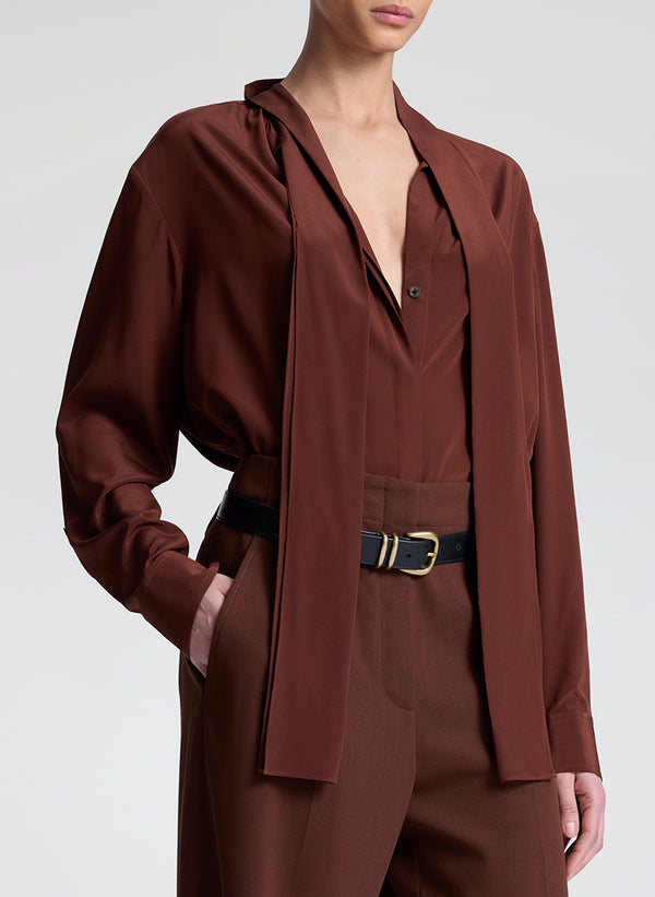 woman wearing brown silk top and matching pants